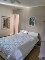 a white bed in a bedroom with two pictures on the wall at Rez de villa tout confort in Furiani