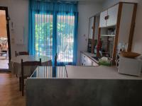 a kitchen with a large window and a table at Rez de villa tout confort in Furiani