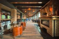 ブレズノにあるHOTEL DOUBLE RED CARS Museumの暖炉、テーブル、椅子が備わるレストラン