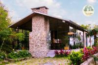 een stenen huis met glazen deuren en bloemen bij TVpalm Ecolodge in Ha Giang