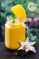 een pot sinaasappelsap met een schijfje sinaasappel en bloemen bij TVpalm Ecolodge in Ha Giang