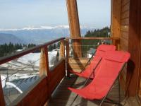 a deck with two red chairs on a balcony at CHAMROUSSE T2 Sud Ski Rando et Vtt aux pieds Les balcons du Recoin in Chamrousse