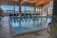 a large swimming pool with chairs in a building at CHAMROUSSE T2 Sud Ski Rando et Vtt aux pieds Les balcons du Recoin in Chamrousse