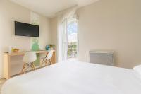a white bedroom with a bed and a desk and a window at Appart’City Confort Tours in Tours