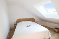 a bedroom with a white bed with a skylight at Lovely flat 5 min away from the Champs Elysées - Paris - Welkeys in Paris