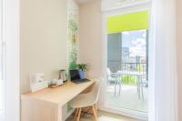 a desk with a laptop on it in a room with a balcony at Appart’City Confort Tours in Tours