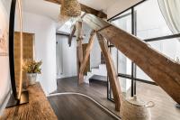 a living room with wooden floors and large windows at Beautiful loft in the 20th district of Paris - Welkeys in Paris