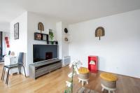 a living room with a television and a chair at Charming 2br a 2 steps from the Stade de France - Welkeys in Saint-Denis