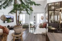 a living room with a potted palm tree in it at Beautiful loft in the 20th district of Paris - Welkeys in Paris