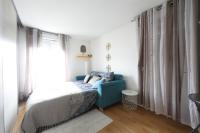 a bedroom with a bed and a blue couch at Charming 2br a 2 steps from the Stade de France - Welkeys in Saint-Denis