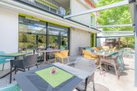 an outdoor patio with tables and chairs and windows at Appart’City Confort Tours in Tours