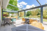 a conservatory with tables and chairs and windows at Appart’City Confort Tours in Tours