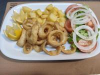 a plate of food with onion rings and vegetables at Hotel Restaurante Las Camelias in Jarrio
