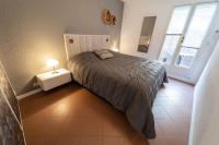a bedroom with a bed and a lamp on a table at Bel appartement hyper centre, direct plage. in Sainte-Maxime