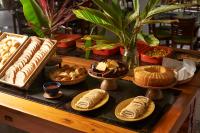 a table topped with different types of bread and pastries at Hotel Recanto da Cachoeira in Socorro