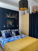 a bedroom with a bed and a blue wall at Charmante maison avec extérieur à deux pas des remparts in Aigues-Mortes
