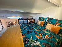 a bedroom with a large bed with a colorful blanket at Charmante maison avec extérieur à deux pas des remparts in Aigues-Mortes