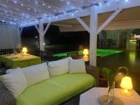 a living room with a green couch and a pool at Love Guadeloupe in Sainte-Anne