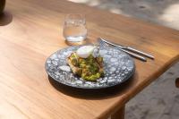 un plato de comida en una mesa de madera en 81 Palms Resort, en Nembrala