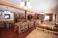 una sala da pranzo con tavoli e sedie in legno di Judith Mountain Lodge a Lewistown