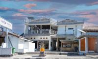 a large white building with a balcony on a street at Dive &amp; Dwell Tulamben in Tulamben