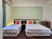 two beds sitting next to each other in a room at East of Love Homestay in Hualien City