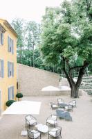 eine Gruppe von Tischen und Stühlen unter einem Baum in der Unterkunft Le Domaine du Fortin in Ménerbes