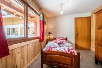 a bedroom with a bed and a window at Coeur de Charmy - 10 personnes in Abondance