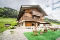 a large wooden house with a yard with chairs at Coeur de Charmy - 10 personnes in Abondance