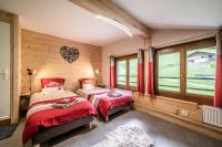 two beds in a room with wooden walls and windows at Coeur de Charmy - 10 personnes in Abondance