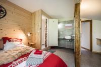 a bedroom with a red bed and a bathroom at Coeur de Charmy - 10 personnes in Abondance