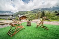 two wooden benches sitting on top of a green lawn at Coeur de Charmy - 10 personnes in Abondance