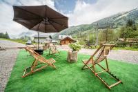 a couple of chairs and an umbrella on the grass at Coeur de Charmy - 10 personnes in Abondance