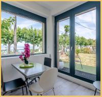 a dining room with a table and chairs and windows at Appartement Cozy 1 Panoramique Lac Léman Thonon-Les-Bains in Thonon-les-Bains