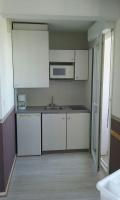 a kitchen with white cabinets and a sink at VACANCES OCEANES in La Rochelle