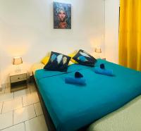 Un dormitorio con una cama grande con sábanas azules. en Auberge K-WAN Hostel - Proche Plages, en Deshaies
