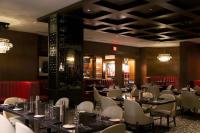 a dining room with tables and chairs and chandeliers at J Resort in Reno