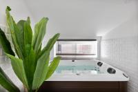 a bath tub with a green plant in a bathroom at Le Cosy Spa &amp; Office au cœur de Toulouse in Toulouse