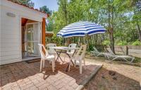 a patio with a table and chairs and an umbrella at 2 Bedroom Beautiful Home In La Faute-sur-mer in La Faute-sur-Mer