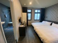 a bedroom with a large bed and a bathroom at Main Inn Taipei in Taipei