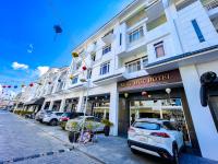 Un gran edificio blanco con coches aparcados delante. en Minh Đức Green Hotel Tuần Châu, en Ha Long