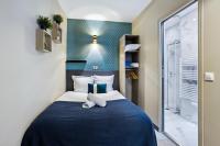 a bedroom with a blue and white bed and a window at Résidence AURMAT - Appart - Hôtel - Boulogne - Paris in Boulogne-Billancourt