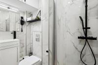 a white bathroom with a shower and a toilet at Résidence AURMAT - Appart - Hôtel - Boulogne - Paris in Boulogne-Billancourt