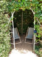 two chairs sitting in a garden with a hedge at Magnifiques maisons de campagne au sein d&#39;un vignoble in Cazouls-lès-Béziers
