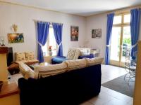 a living room with a couch and blue curtains at Magnifiques maisons de campagne au sein d&#39;un vignoble in Cazouls-lès-Béziers