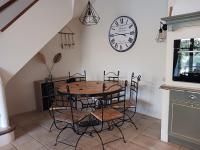 a dining room with a table and a clock on the wall at Magnifiques maisons de campagne au sein d&#39;un vignoble in Cazouls-lès-Béziers