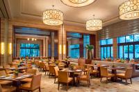 uma sala de jantar com mesas, cadeiras e janelas em Sheraton Huizhou Bailuhu em Huizhou