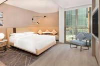 a bedroom with a large white bed and a chair at Sheraton Abu Dhabi Hotel & Resort in Abu Dhabi