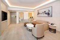 a living room with a couch and a table and chairs at Sheraton Abu Dhabi Hotel & Resort in Abu Dhabi