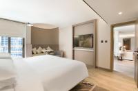 a bedroom with a white bed and a living room at Sheraton Abu Dhabi Hotel & Resort in Abu Dhabi